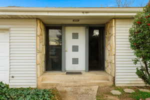 Doorway to property featuring stone siding