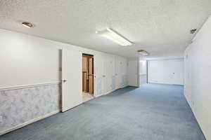 Spare room featuring a textured ceiling and carpet flooring