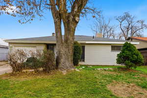 View of home's exterior with a chimney, a garage, roof with shingles, and driveway