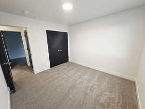 Unfurnished bedroom with carpet floors and a closet