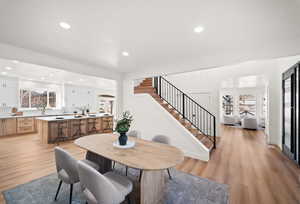 Dining space with stairway, light wood finished floors, recessed lighting, and plenty of natural light