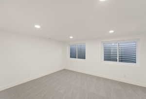 Carpeted spare room featuring recessed lighting