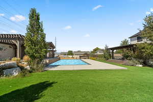 Swimming pool featuring a pergola, a patio area, and a yard