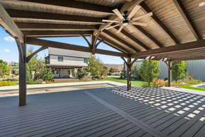 Wooden deck with a ceiling fan and a yard