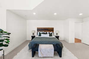 Bedroom with light colored carpet and recessed lighting