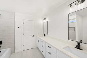 Bathroom featuring double vanity and tub / shower combination