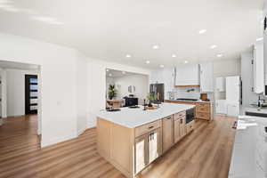 Kitchen featuring light brown cabinetry, light stone counters, light wood-style floors, recessed lighting, and white cabinetry