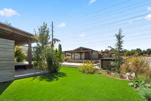 View of green lawn with a wooden deck