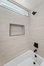 Bathroom featuring shower / washtub combination and a textured ceiling