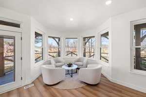Living area with light wood-style floors and recessed lighting