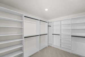 Walk in closet featuring light carpet