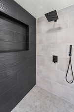 Bathroom with tiled shower and a textured ceiling