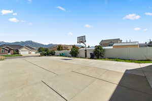 View of basketball court featuring a mountain view and basketball hoop
