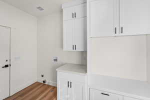 Laundry room with washer hookup, wood finished floors, and cabinet space