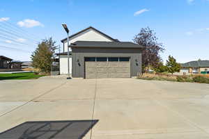 View of property exterior with board and batten siding and concrete driveway