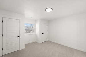 Spare room with light carpet and a textured ceiling