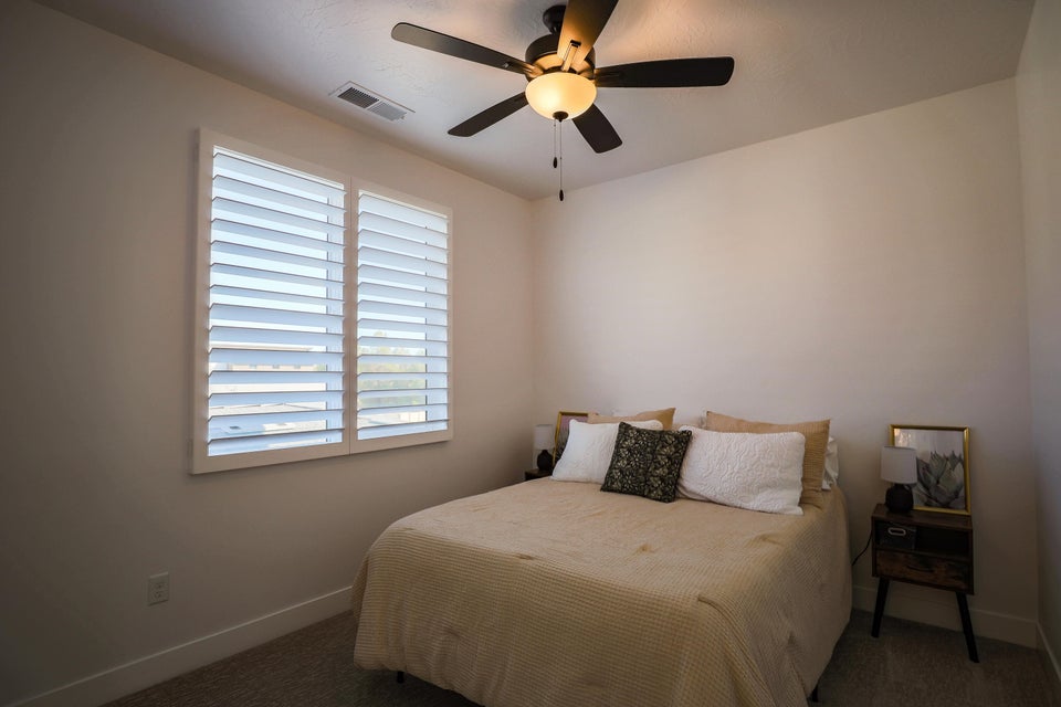 Bedroom with ceiling fan and carpet