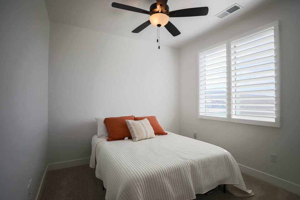 Bedroom with ceiling fan and carpet