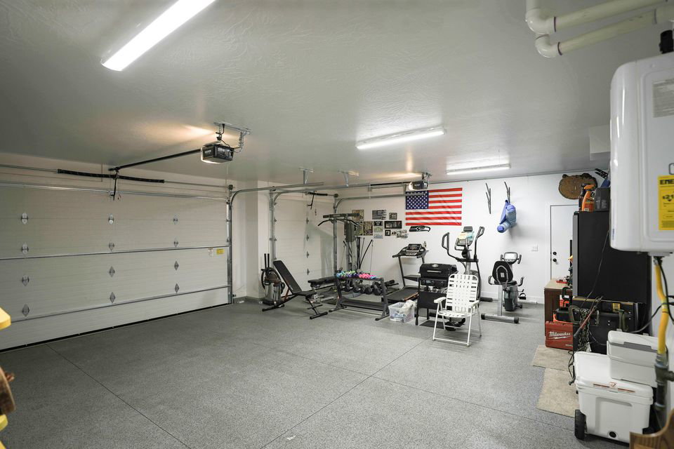 Garage featuring water heater and a garage door opener