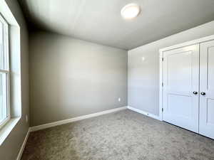 Unfurnished bedroom featuring carpet and a closet