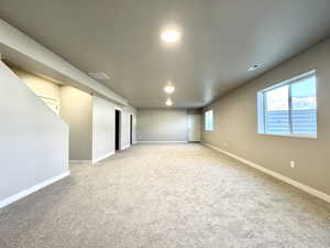 Carpeted spare room with baseboards