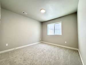 Spare room with a textured ceiling and carpet flooring