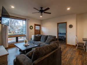 Living area with dark wood-style flooring, recessed lighting, and a ceiling fan