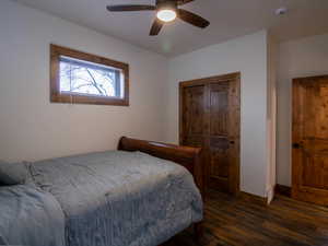 Bedroom featuring dark wood finished floors, a ceiling fan, and a closet