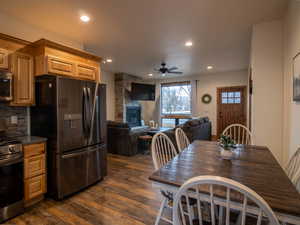 Kitchen featuring appliances with stainless steel finishes, recessed lighting, dark wood-style flooring, ceiling fan, and open floor plan