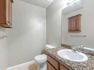Half bath featuring light tile patterned flooring and vanity