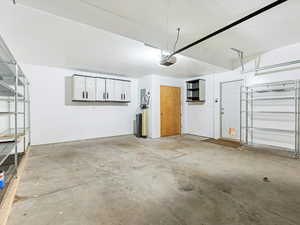 Garage featuring electric panel and a garage door opener