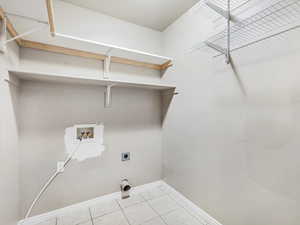 Washroom with washer hookup, light tile patterned floors, and hookup for an electric dryer