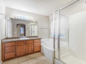 Bathroom with vanity, a bath, a shower stall, and light tile patterned flooring