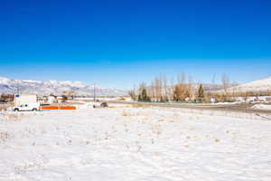 Yard layered in snow with a mountain view