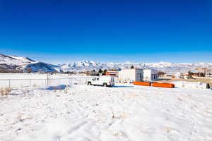 Snowy yard featuring a mountain view