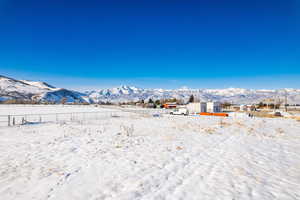 Yard layered in snow featuring a mountain view