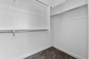 Walk in closet featuring dark carpet