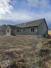Rear view of property with a shingled roof