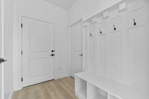 Mudroom with light wood-type flooring and baseboards