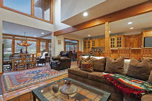 Tiled living area featuring a chandelier, recessed lighting, and beamed ceiling