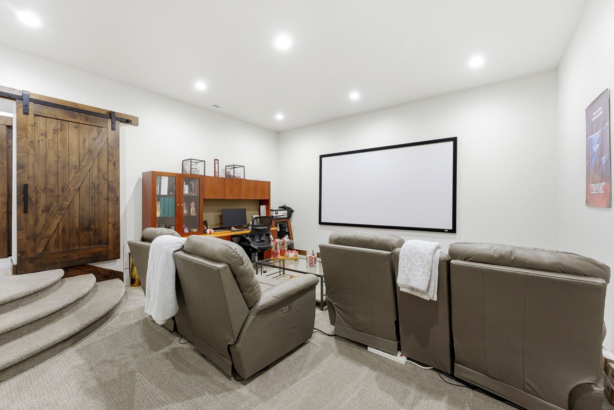 Carpeted home theater with a barn door and recessed lighting