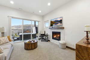 Carpeted living room with a fireplace and recessed lighting