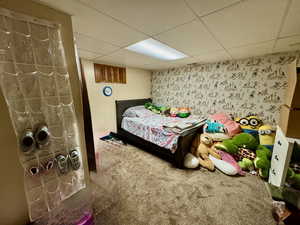 Bedroom featuring carpet floors and a drop ceiling