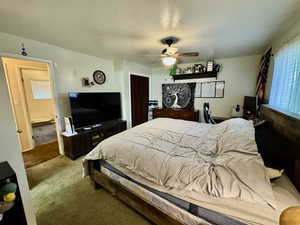 Bedroom featuring carpet flooring, ceiling fan, a textured ceiling, and baseboard heating