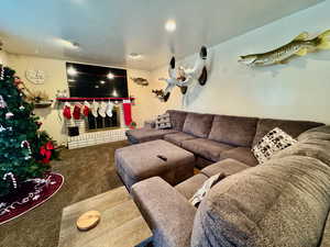 Carpeted living room with a brick fireplace and a textured ceiling