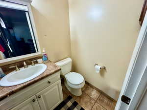 Half bath featuring vanity and dark tile patterned flooring