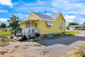 View of front of home with roof with shingles and a porch