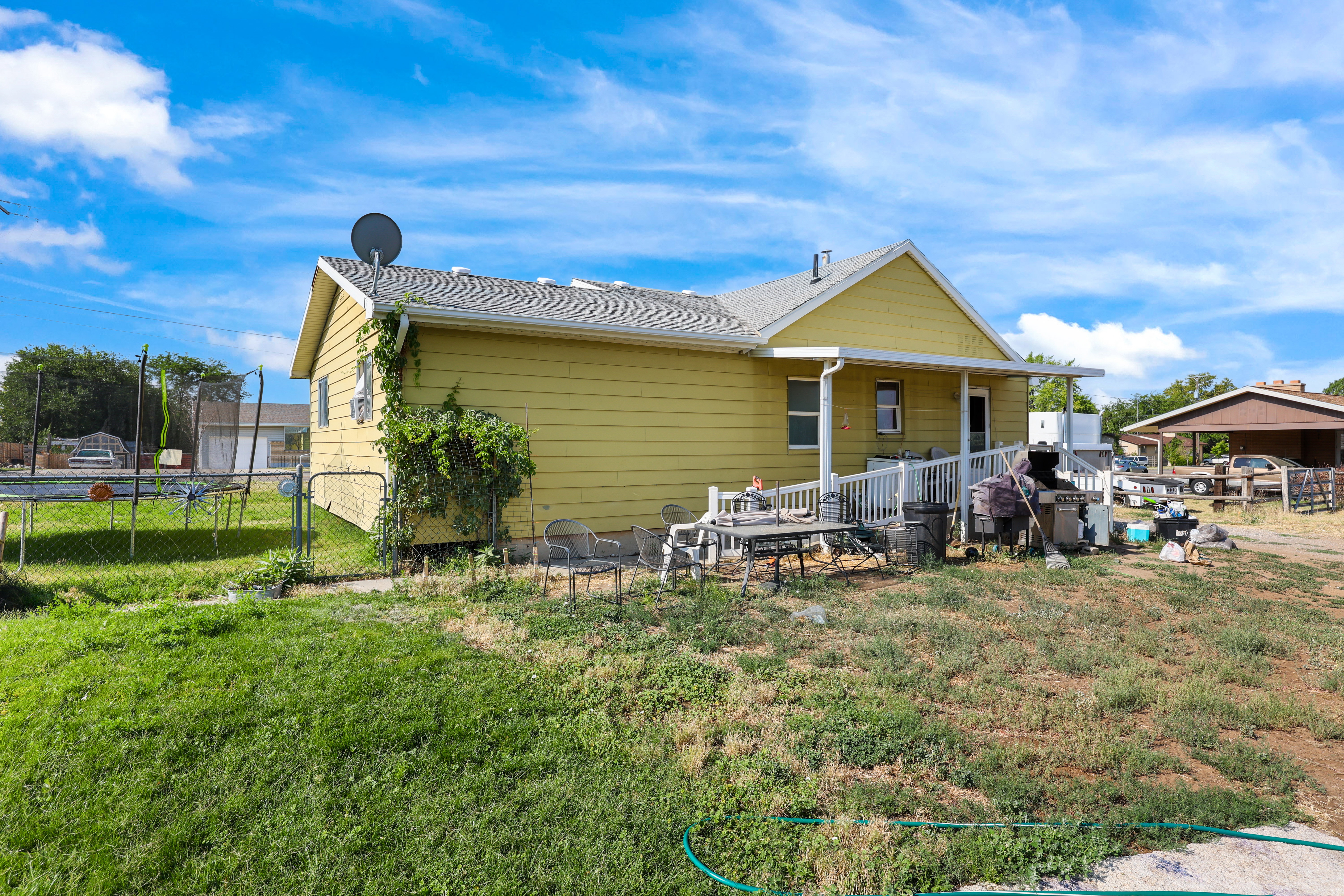 Rear view of house featuring a trampoline