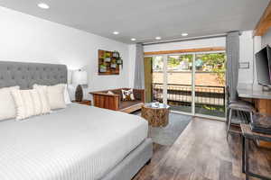 Bedroom featuring recessed lighting, wood finished floors, and access to exterior