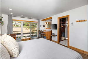 Bedroom with access to outside, recessed lighting, and a spacious closet